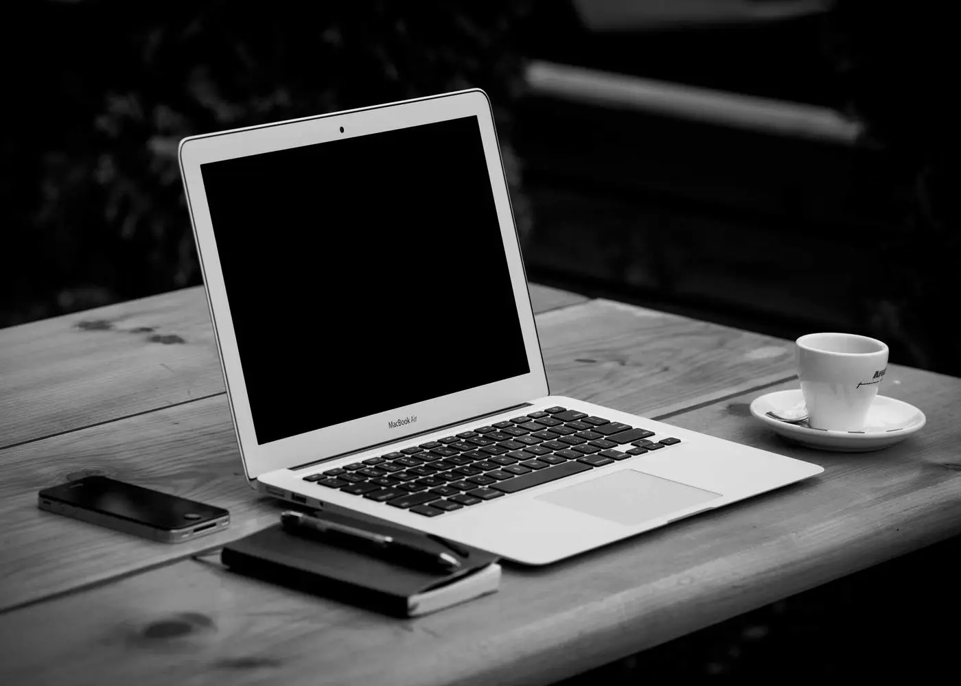 Laptop, phone and coffee cup on a wooden table